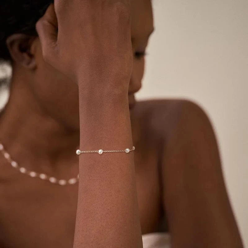 bracelet doré élégant avec perles blanches, accessoire chic pour mariage ou soirée habillée femme