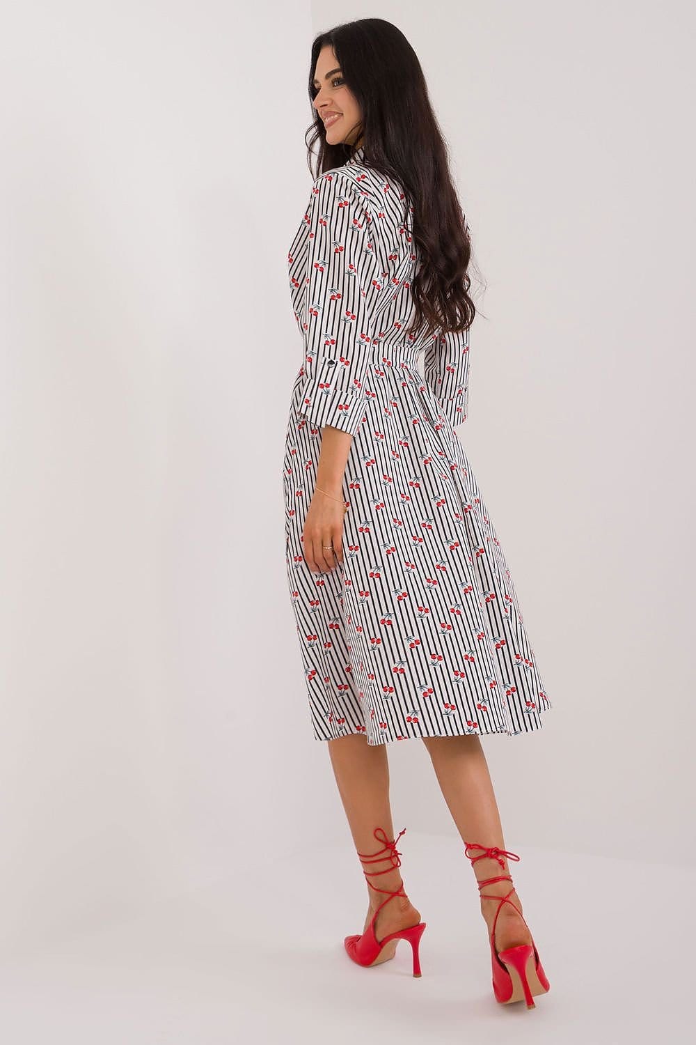 Robe midi blanche à motifs floraux rouges et lignes noires, style chic casual, manches longues, idéale pour cocktail ou soirée.