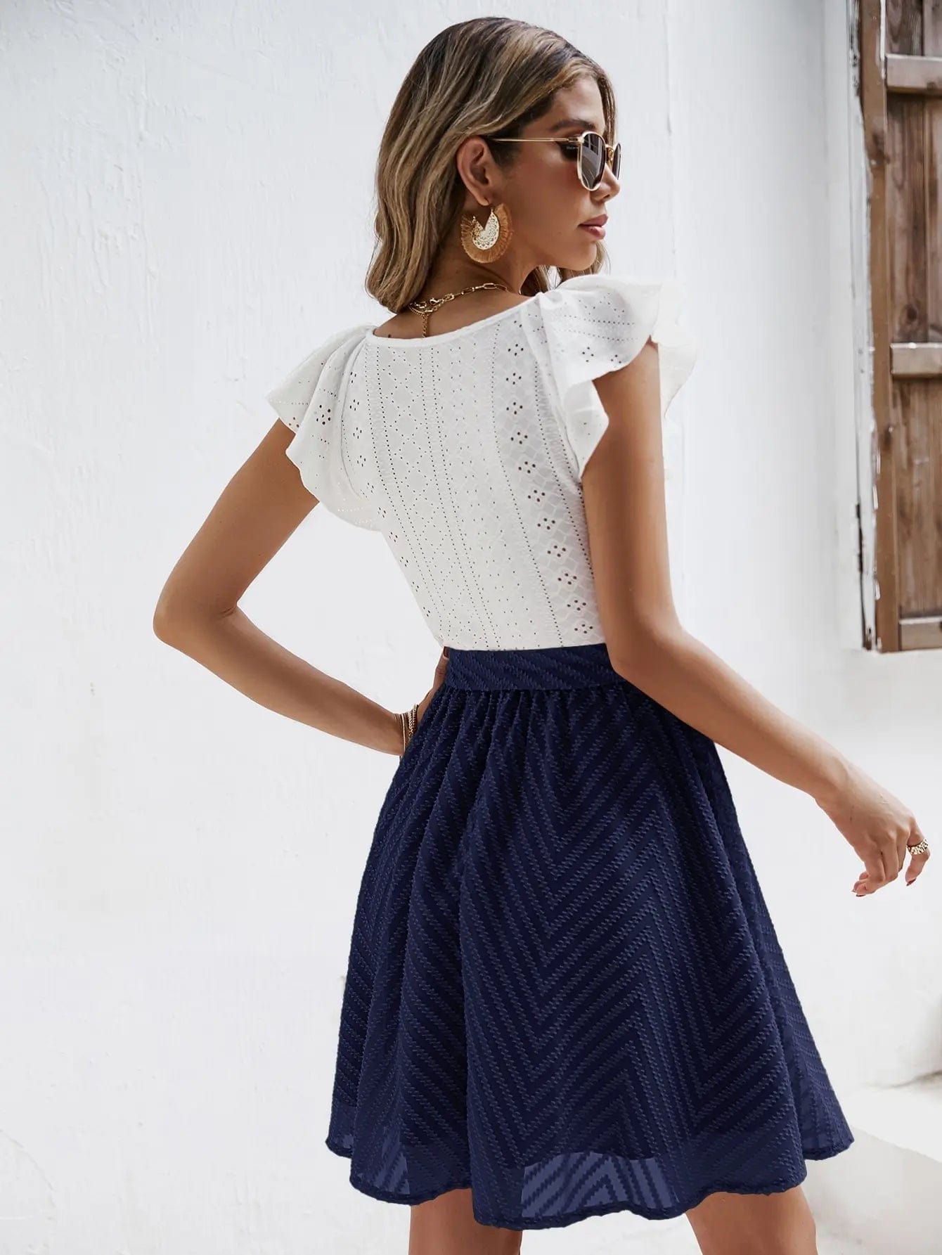 Robe chic blanche et bleue avec jupe à nouer et top en dentelle, manches courtes, idéale pour cocktail ou soirée.