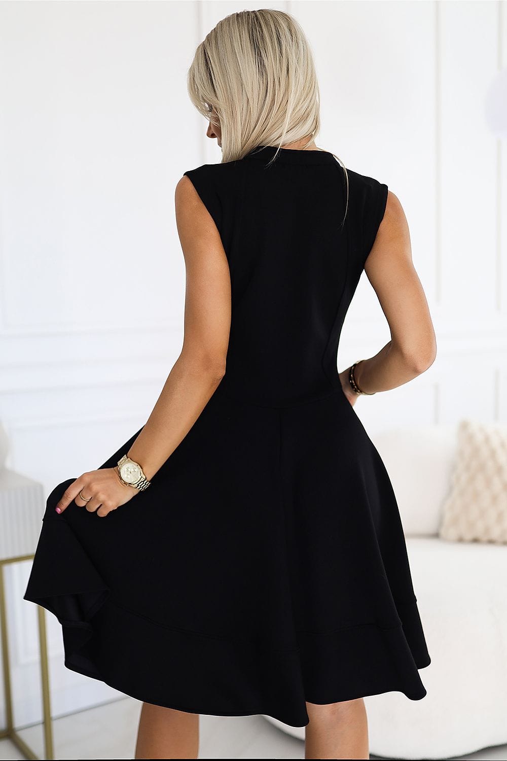 Robe noire soirée chic sans manches, courte et trapèze, parfaite pour un cocktail élégant.