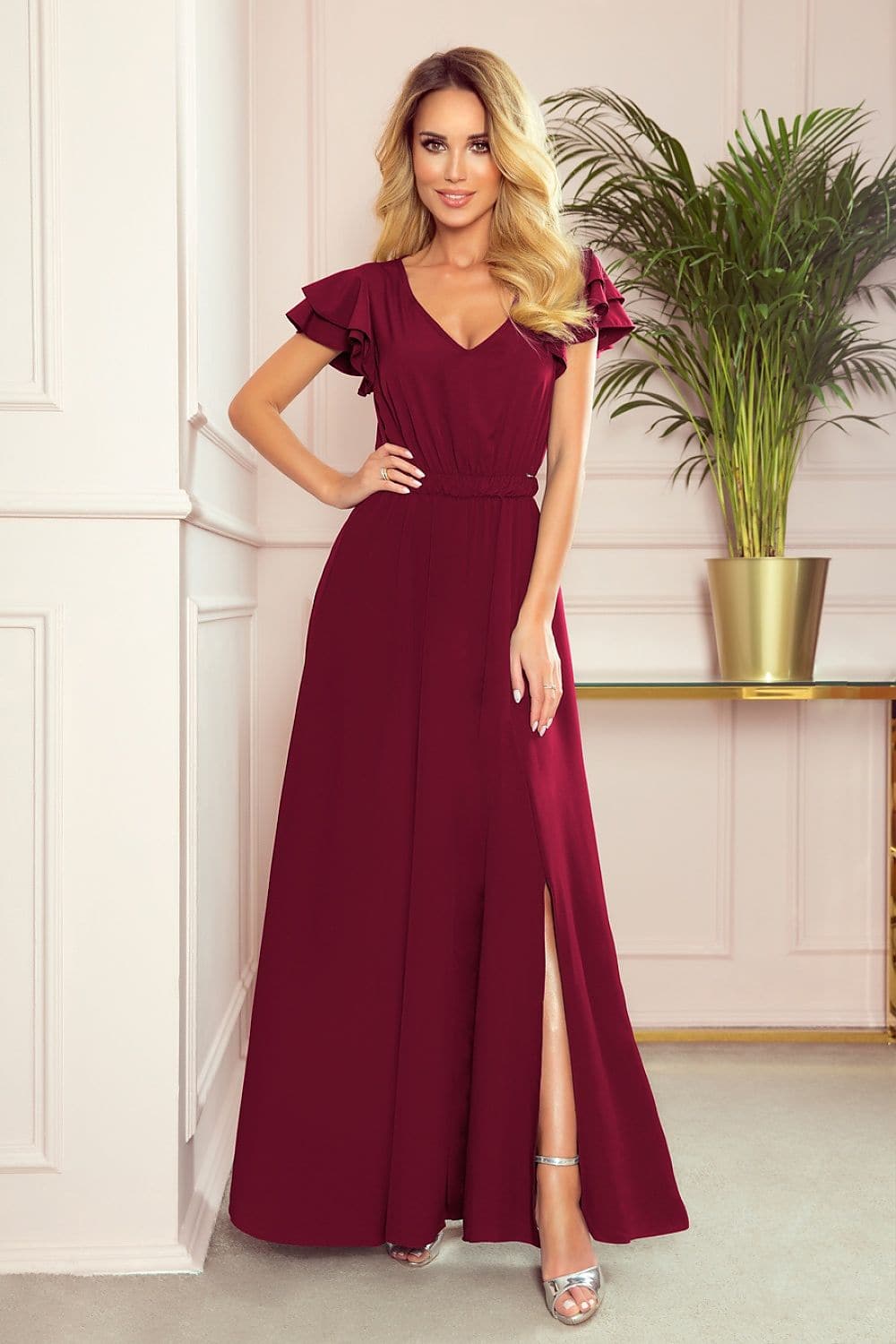 Robe de soirée chic bordeaux longue sans manches avec détails volants pour événement élégant et style féminin.