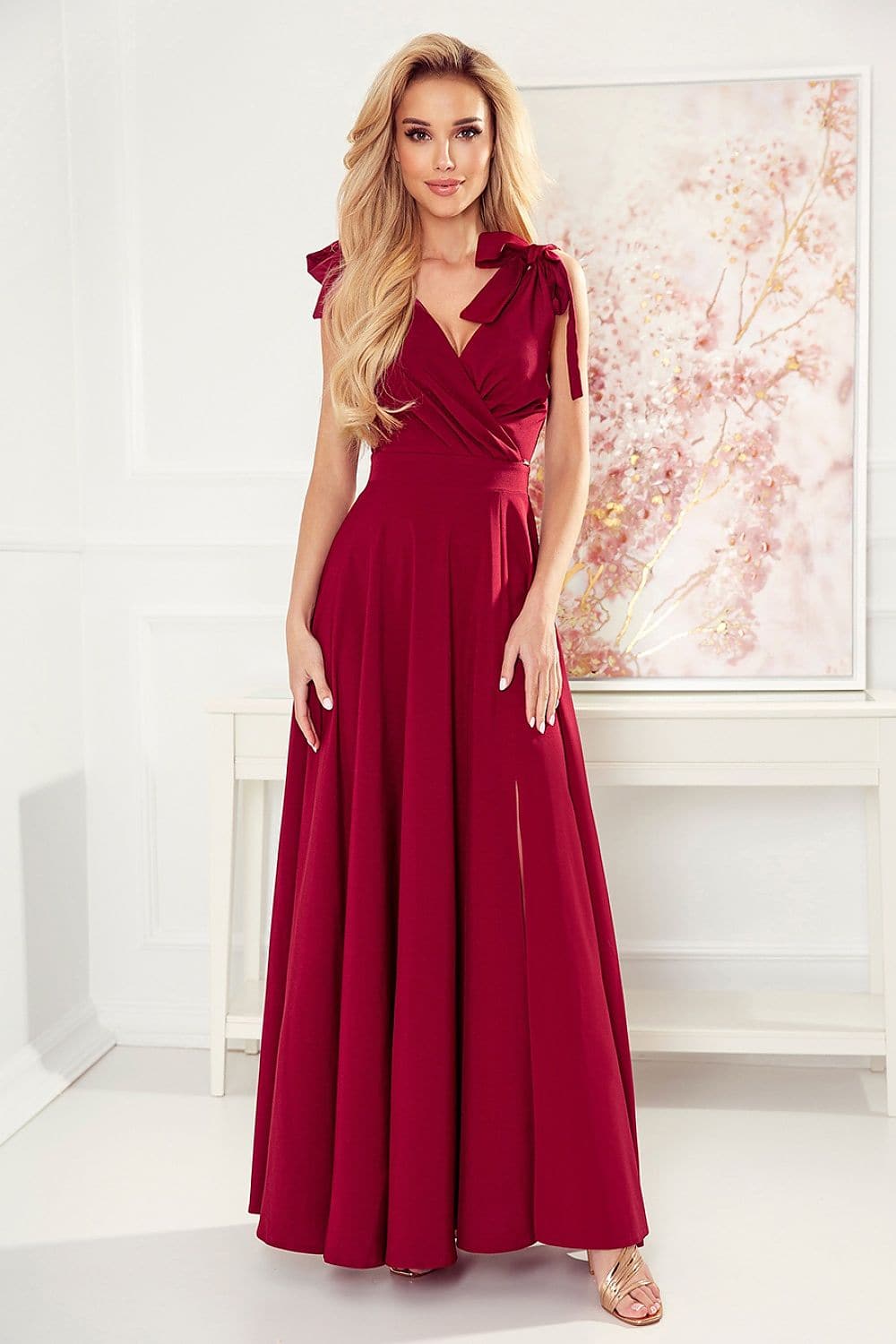Robe de soirée chic rouge longue avec épaules dénudées et noeud, idéale pour gala ou événement formel.