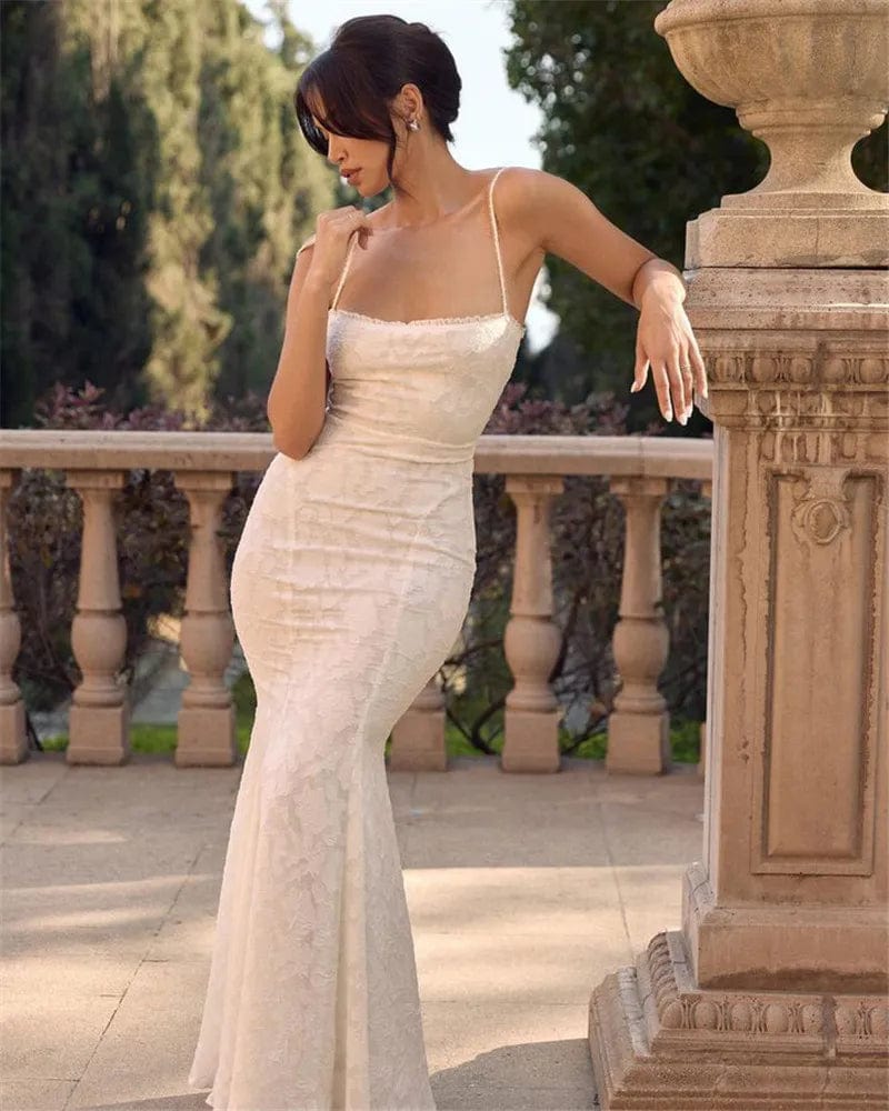 Robe longue en dentelle blanche, style chic et vintage, idéale pour mariage, avec silhouette trapèze et sans manches.