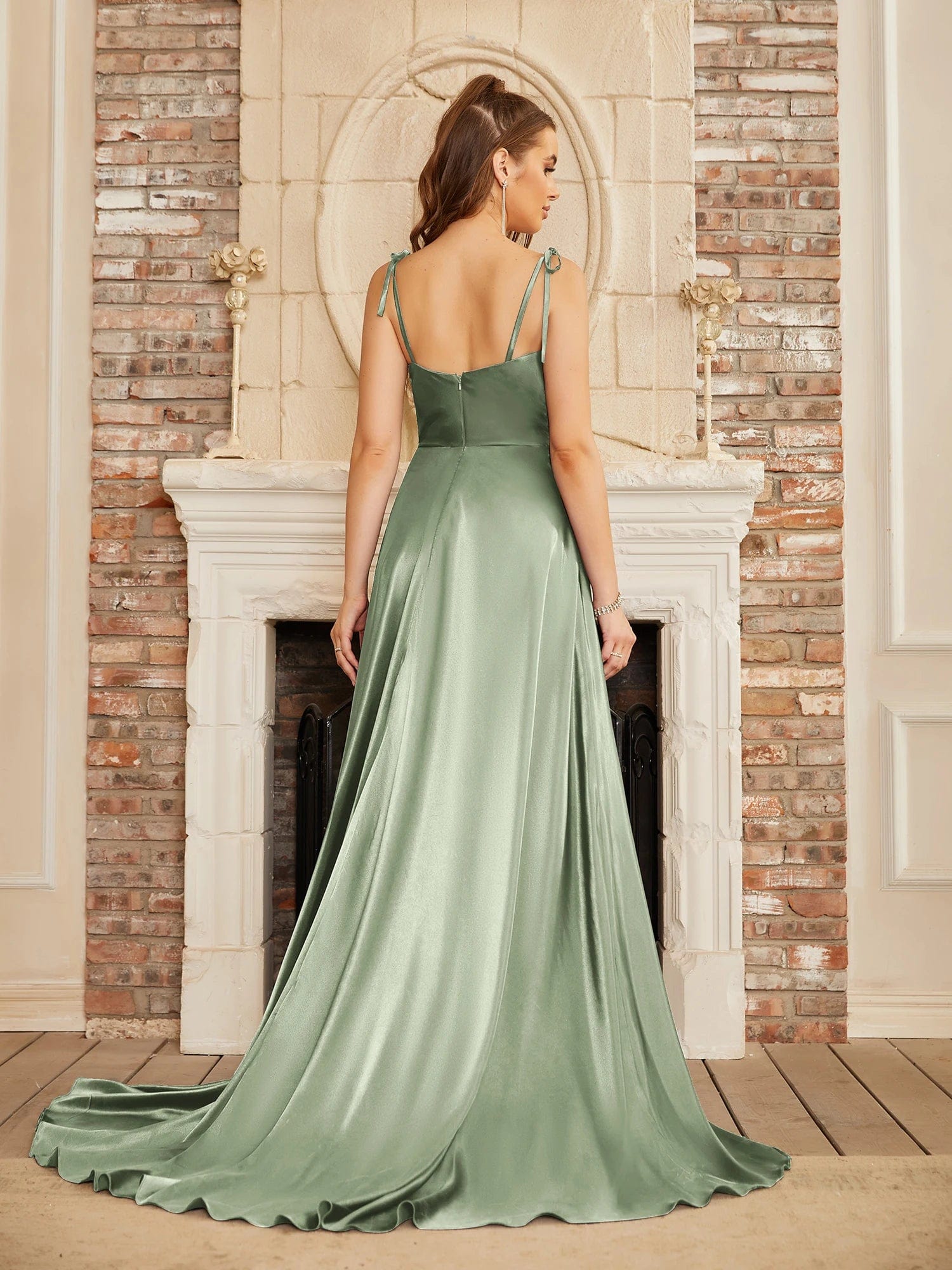 Robe longue vert sauge pour mariage invité chic avec silhouette évasée et fendue sans manches.