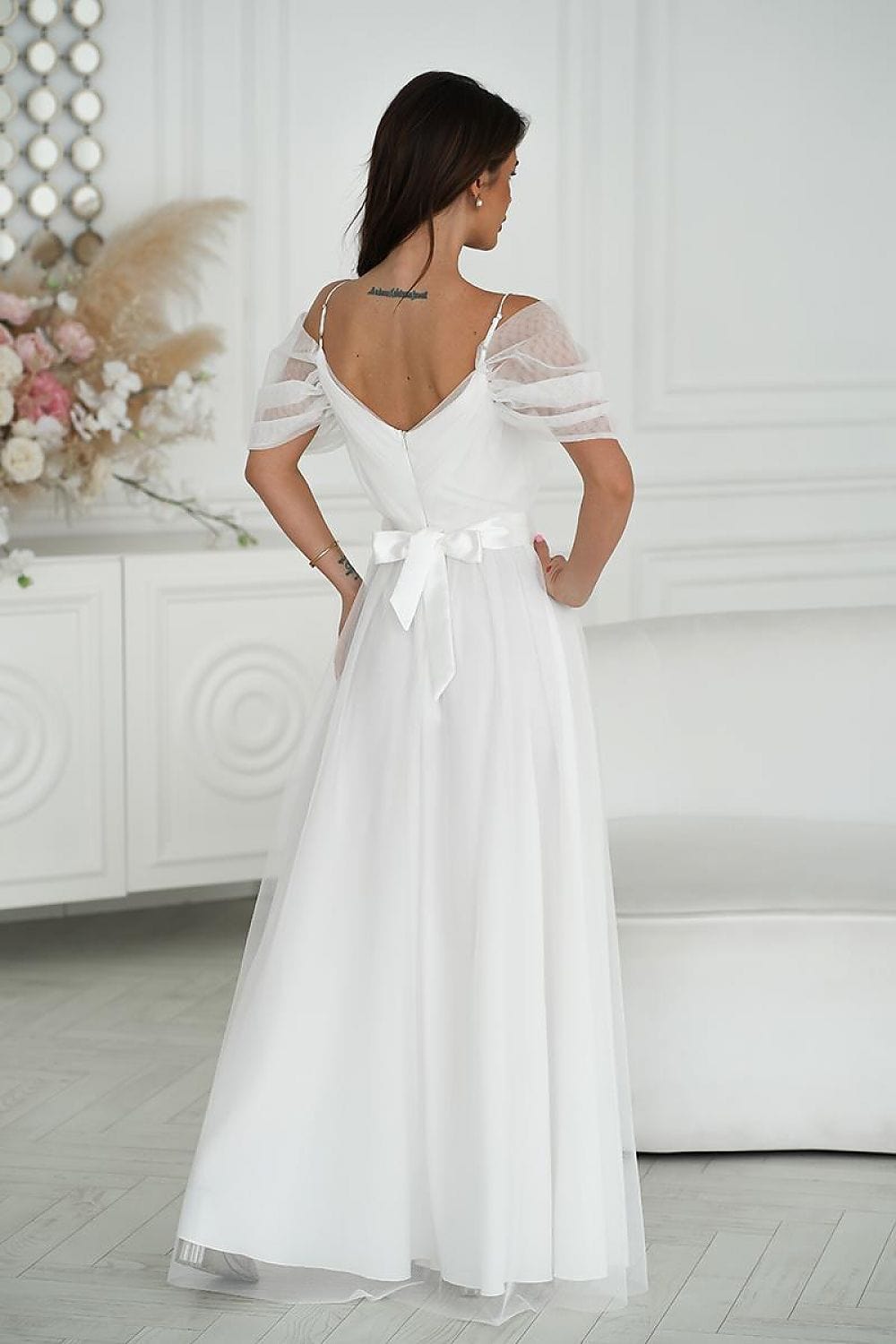 Robe de mariée bohème blanche longue avec manches courtes et silhouette évasée élégante.
