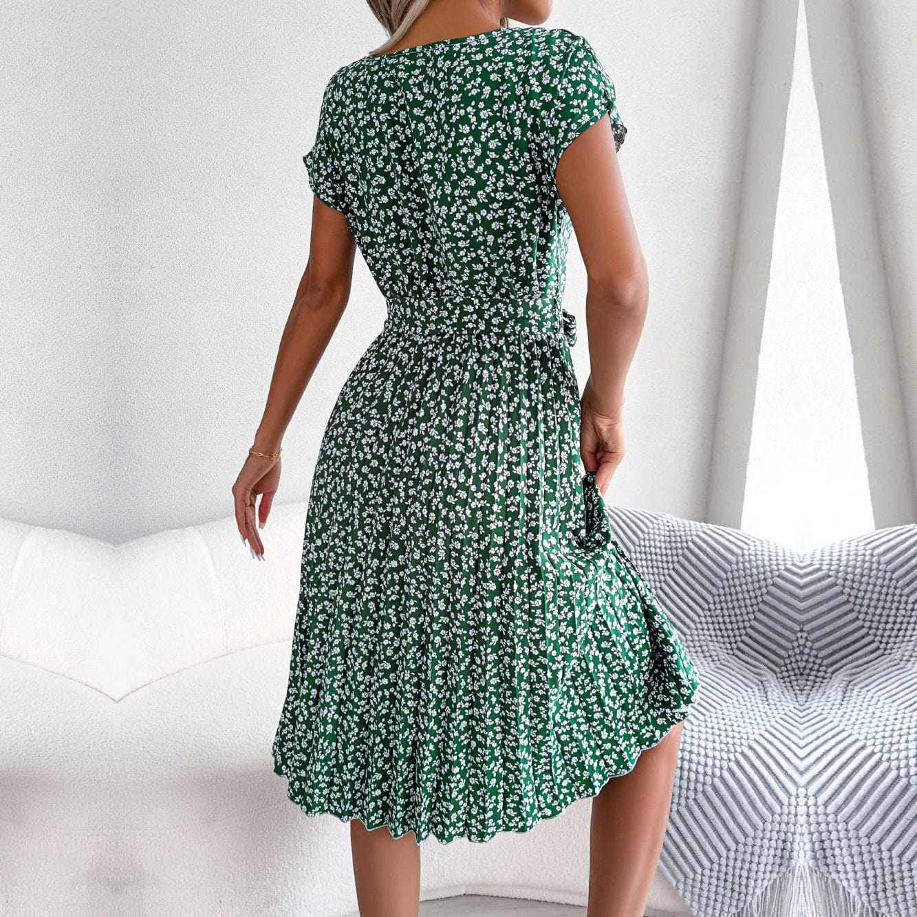 Robe midi fleurie verte à ceinture à nouer pour cocktail ou événement estival, adaptée pour une silhouette trapèze avec manches courtes.
