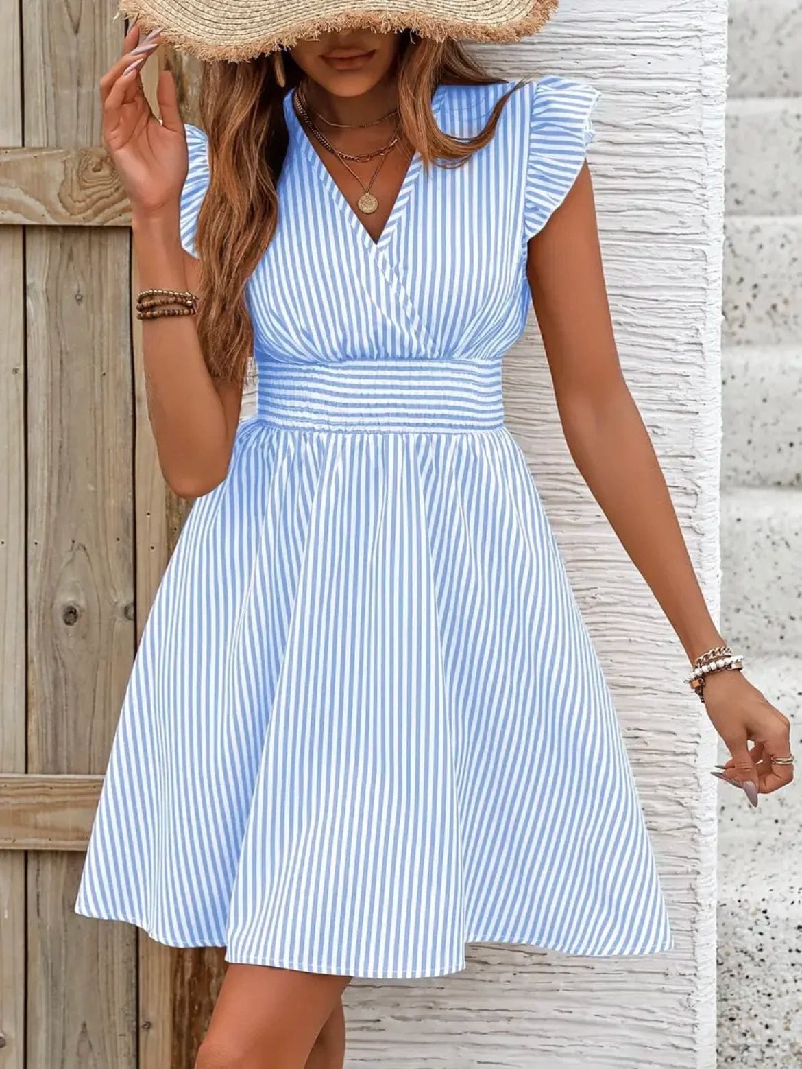 Robe rayée bleu et blanc à décolleté en V, courte et fluide pour été, avec manches courtes et silhouette évasée.