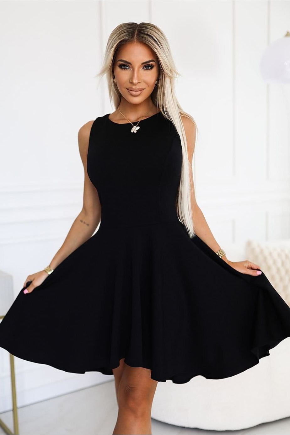 Robe noire soirée chic courte, sans manches, parfaite pour mariage invité chic ou cocktail.