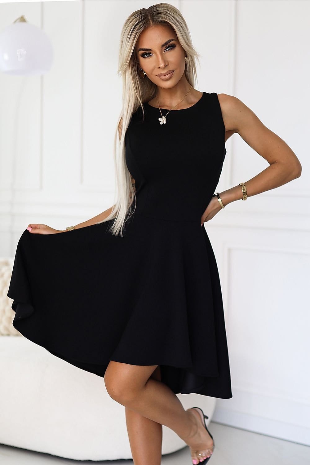 Robe de soirée chic noire courte sans manches, parfaite pour un événement d'élégance intemporelle.