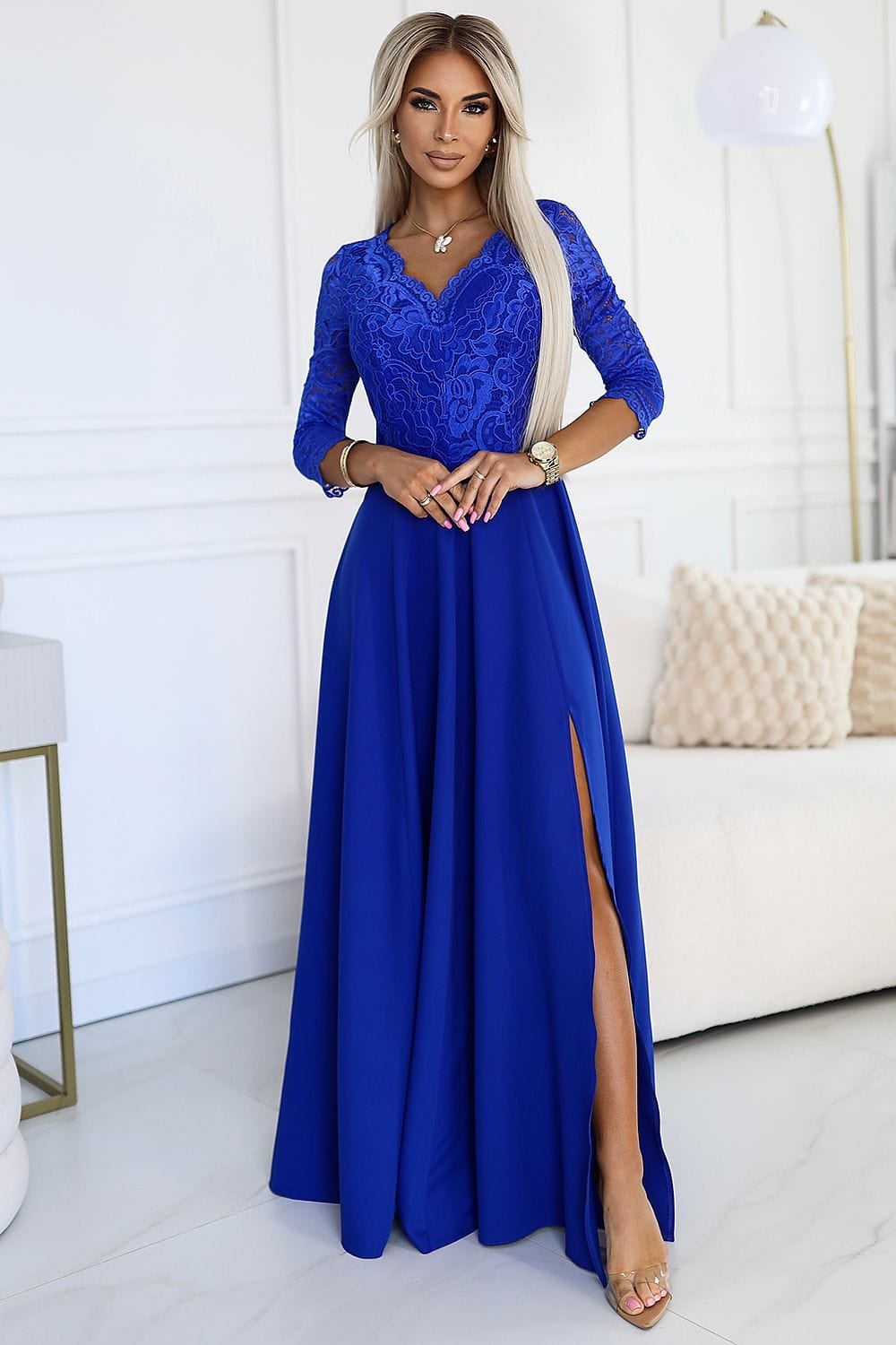 Robe de soirée chic bleue longue manches trois-quarts en dentelle pour événement élégant.