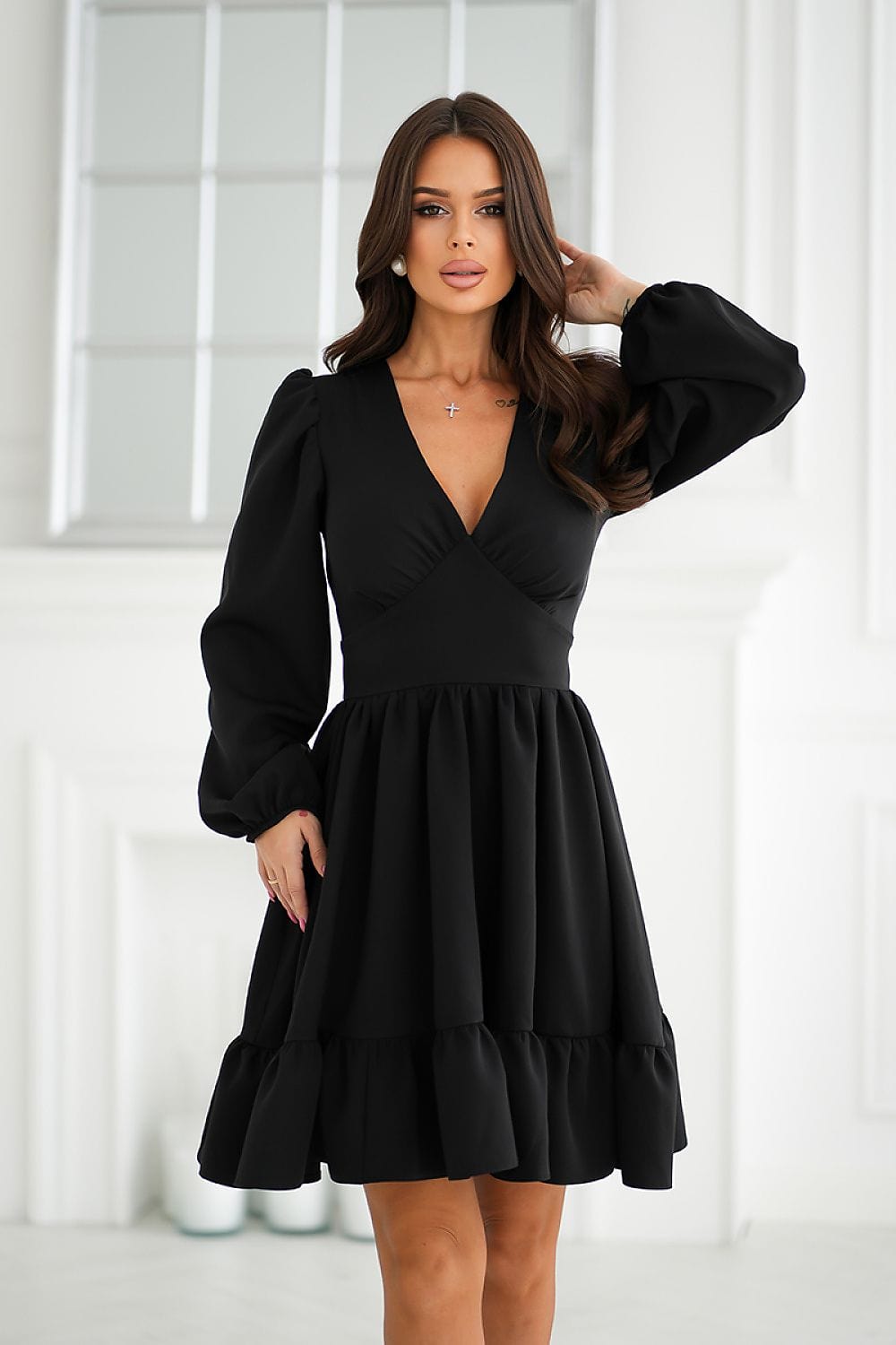 Robe noire courte soirée chic avec manches longues et silhouette trapèze, idéale pour un cocktail.