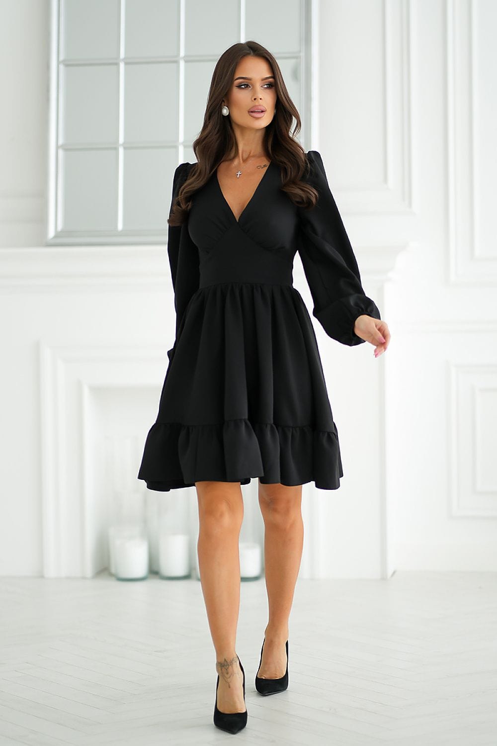 Robe noire soirée chic courte avec manches longues, idéale pour un événement élégant.