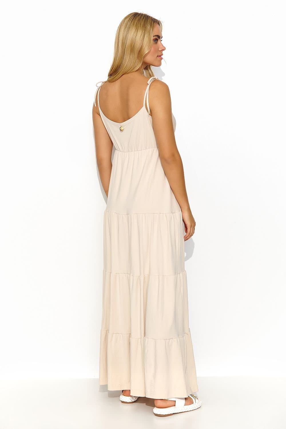 Robe beige style Empire longue idéale pour soirée chic ou mariage, avec silhouette fluide et sans manches pour une élégance intemporelle.