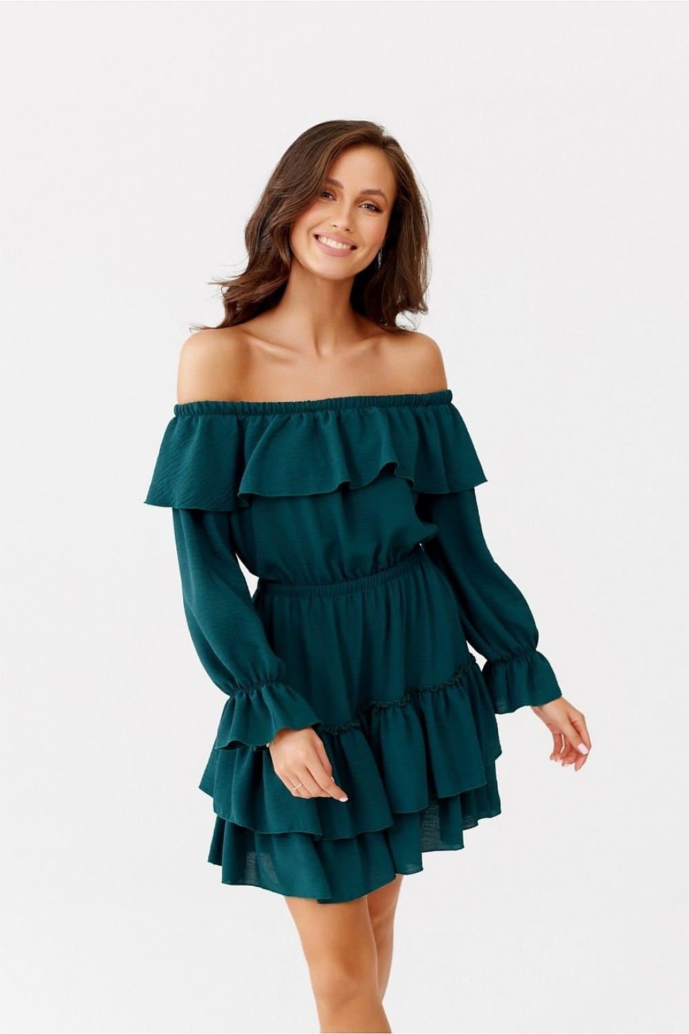 Robe de cocktail verte à épaules dénudées et volants superposés, longueur courte, idéale pour soirée ou événement chic.