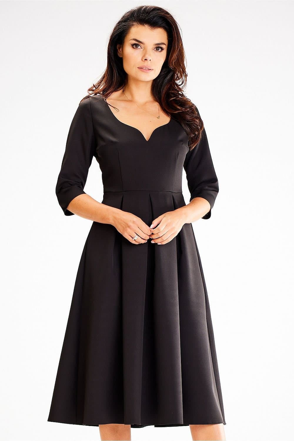 Robe noire chic mi-longue à manches trois-quarts et silhouette trapèze, idéale pour cocktail ou soirée.