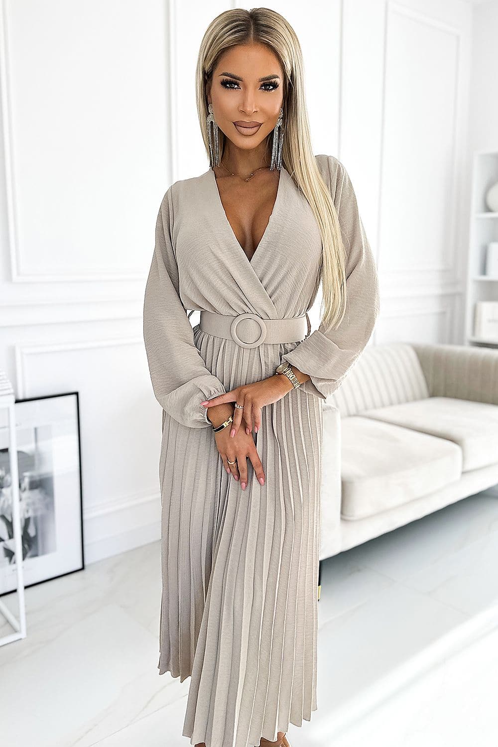 Robe plissée beige mi-longue chic pour cocktail ou soirée, manches longues et ceinture élégante, silhouette droite, parfaite pour évènement formel.