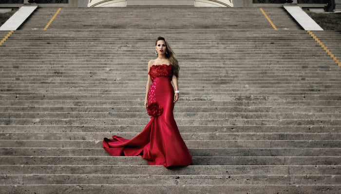 une femme en robe rouge sur des marches d'escalier