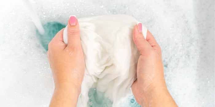 Femme qui lave sa robe blanche jaunie