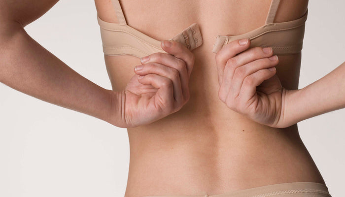 femme qui met un soutien-gorge dos nu