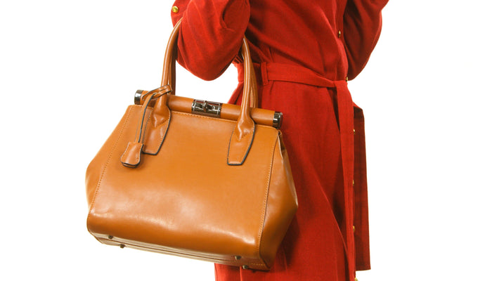 femme avec sac marron et robe rouge