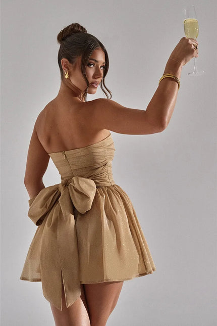 Robe bustier courte dorée à paillette pour soirée cocktail, sans manches avec nœud, idéale pour évènement chic et élégant.