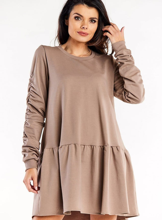 Robe cocktail grossesse beige manches longues et trapèze pour femme enceinte confortable et élégante.