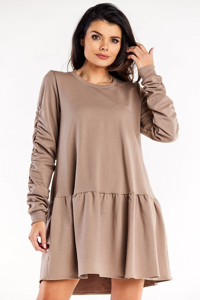 Robe cocktail grossesse beige manches longues et trapèze pour femme enceinte confortable et élégante.