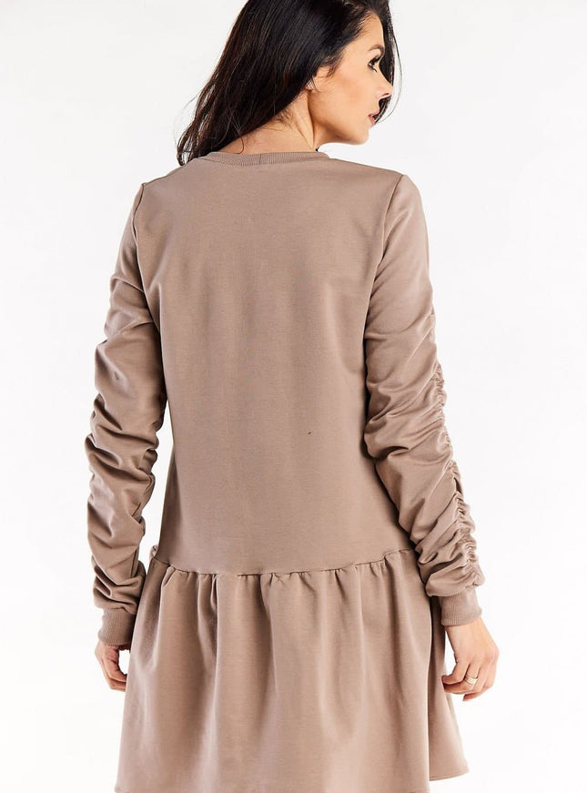 Robe cocktail grossesse beige, manches longues, longueur midi pour femme enceinte, style chic et confortable.