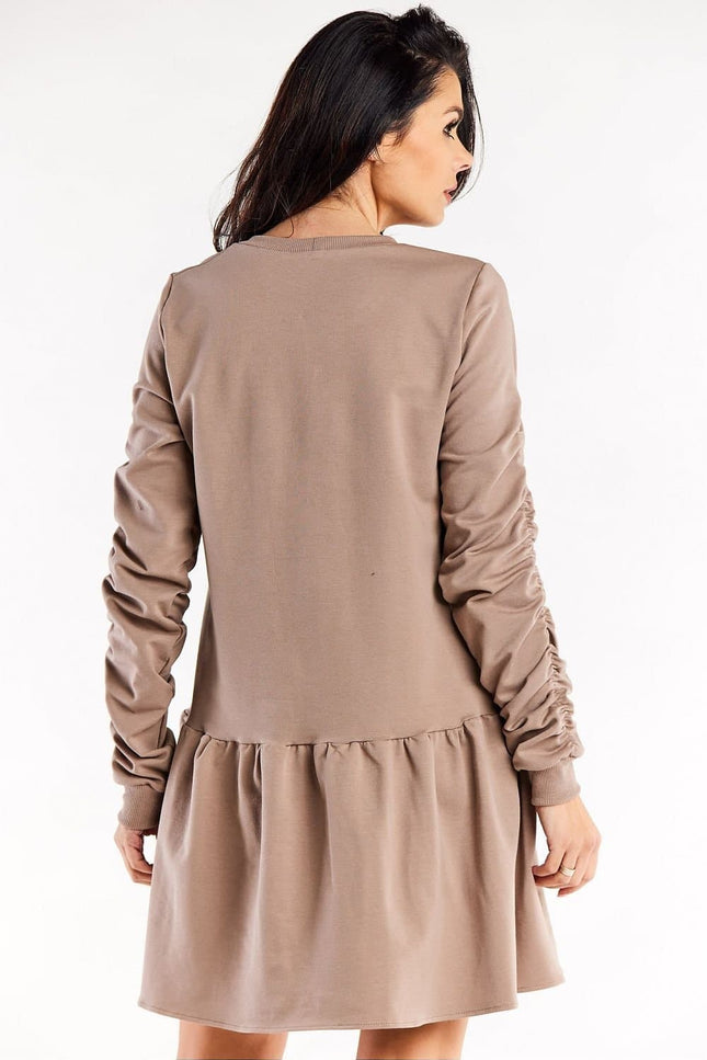 Robe cocktail grossesse beige, manches longues, longueur midi pour femme enceinte, style chic et confortable.