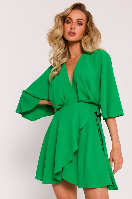 Robe de cocktail verte à manches courtes et jupe trapèze, style chic et féminin pour événements, longueur midi.