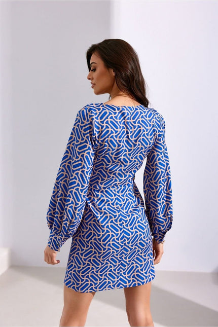 Robe de cocktail chic bleue et blanche avec manches longues, motif géométrique, coupe droite, longueur courte idéale pour soirée.