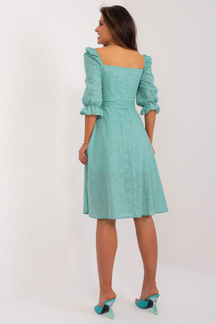 Robe verte de soirée en dentelle, style midi avec manches courtes et silhouette trapèze, parfaite pour cocktail ou événement chic.