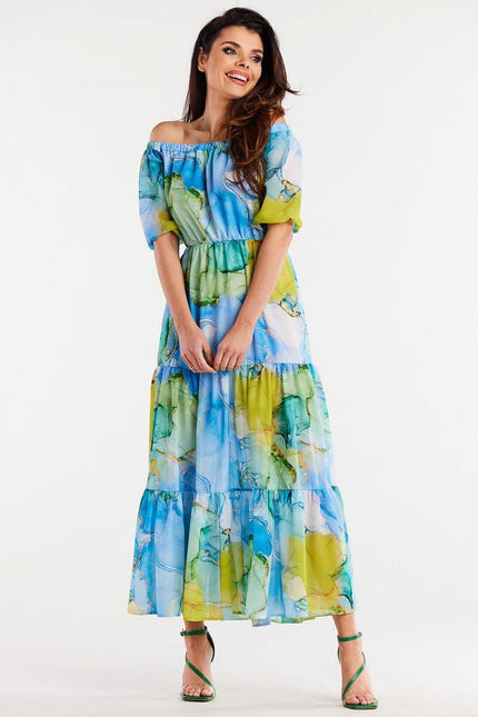 Robe bohème fleurie longue idéale pour l'été avec manches courtes et couleurs bleu, vert et jaune.