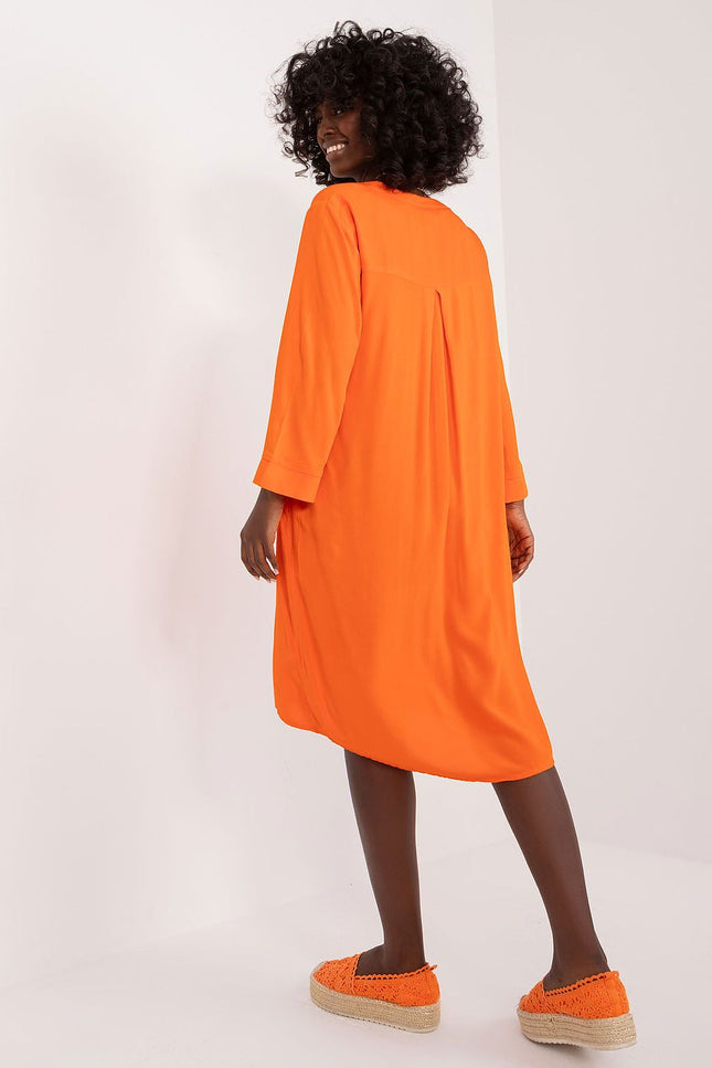 Robe orange fluide à manches longues et de longueur midi, idéale pour un look casual ou une soirée simple.