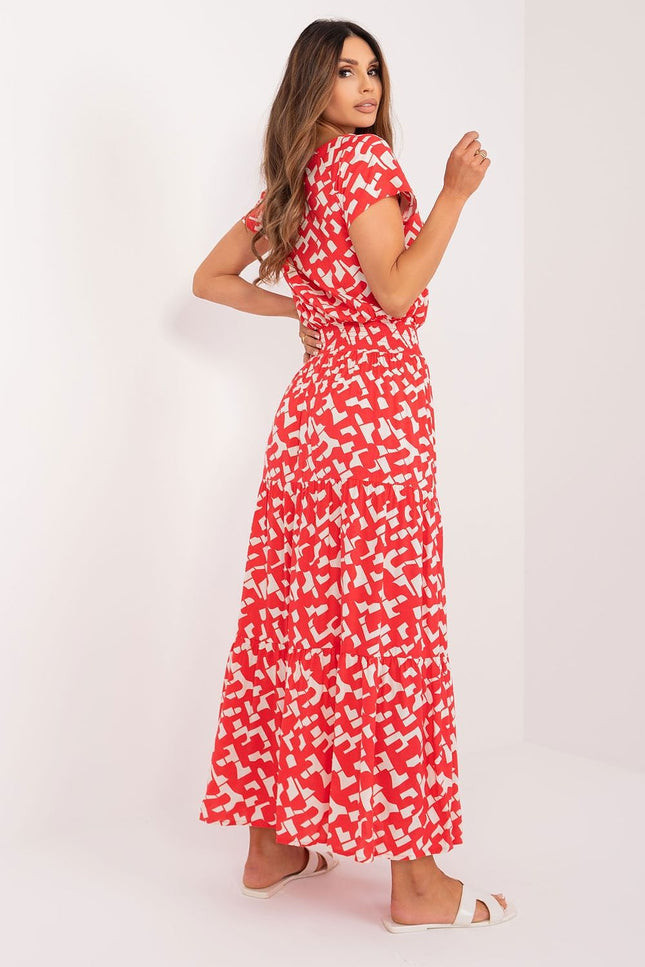 Robe d'été longue évasée rouge à motifs blancs, sans manches, idéale pour soirée décontractée ou balade sur la plage.