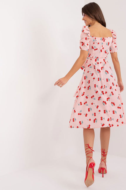 Robe d'été rose à motif cerises avec encolure carrée, manches courtes et silhouette trapèze pour cocktail et journée estivale.