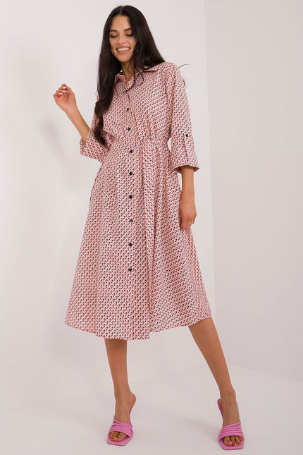 Robe rose mi-longue à manches courtes et col chemise pour cocktail ou soirée chic, avec motif géométrique.