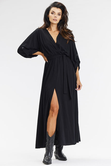 Robe noire élégante pour cocktail, manches longues et fendue, idéale pour une soirée chic.