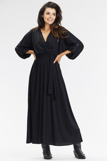 Robe noire longue manches longues chic pour soirée cocktail, silhouette droite avec ceinture.