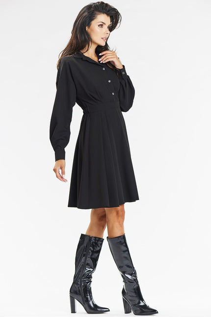 Robe noire chic midi à manches longues pour soirée cocktail ou événement d'entreprise.