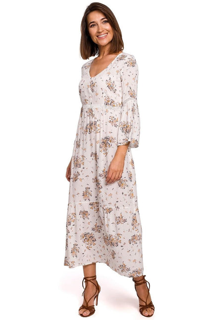 Robe bohème beige à fleurs avec manches longues et longueur midi, idéale pour un style casual ou événements champêtres.