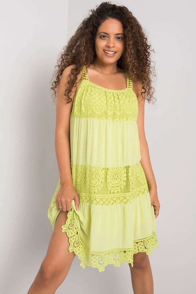 Robe de plage jaune en dentelle courte, style casual avec fines bretelles pour un look estival et décontracté.