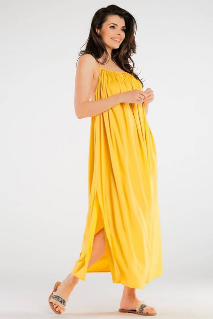 Robe jaune fluide midi sans manches idéale pour une soirée d'été décontractée ou une promenade à la plage.