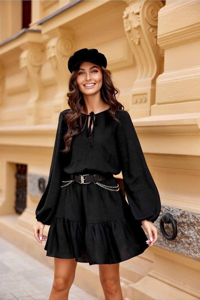 Robe soirée chic noire courte avec manches longues et ceinture, idéale pour cocktail ou événement élégant.