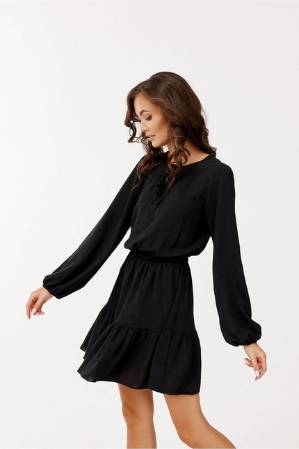 Robe soirée chic noire courte avec manches longues pour cocktail ou évènement élégant, silhouette droite et fluide.