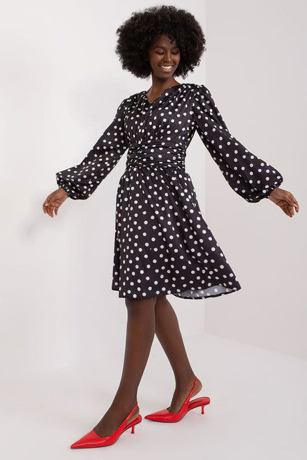 Robe à pois manche longue noire midi pour soirée, style vintage et élégant, silhouette trapèze, idéale cocktail ou événement.