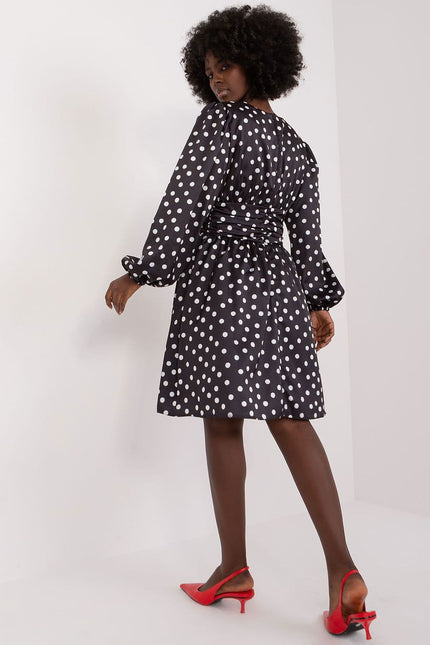 Robe à pois manche longue noire, style vintage et cocktail, midi et élégante pour événements formels ou soirées.