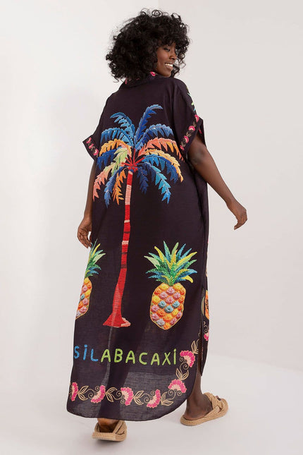 Robe plage noire imprimée midi sans manches avec motifs tropicaux et pompons pour une allure décontractée et estivale.