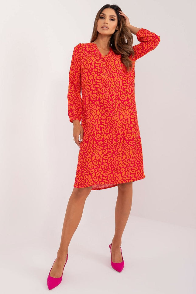 Robe asymétrique rouge à motif orange avec manches longues, idéale pour cocktail ou soirée élégante, coupe midi.