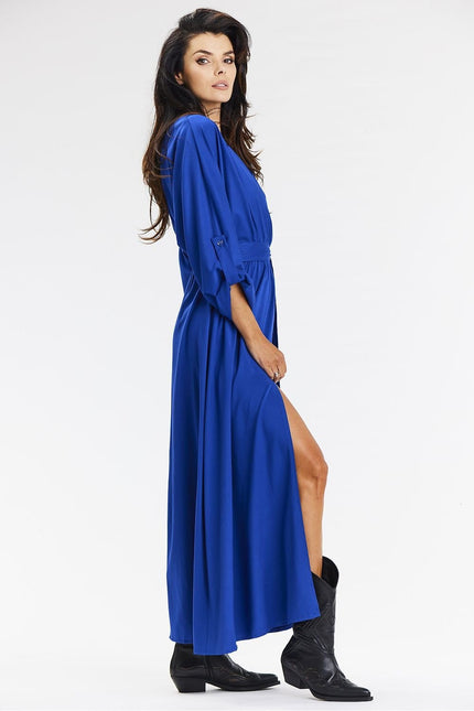 Robe bleue élégante longue à manches longues et fente latérale, parfaite pour un cocktail ou une soirée chic.